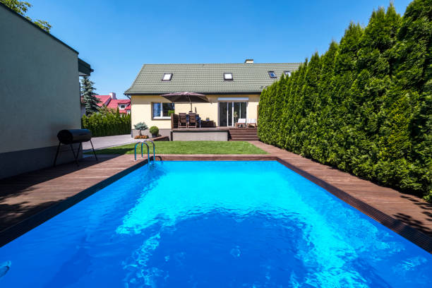 swimming pool in the garden of house with trees during summer. real photo